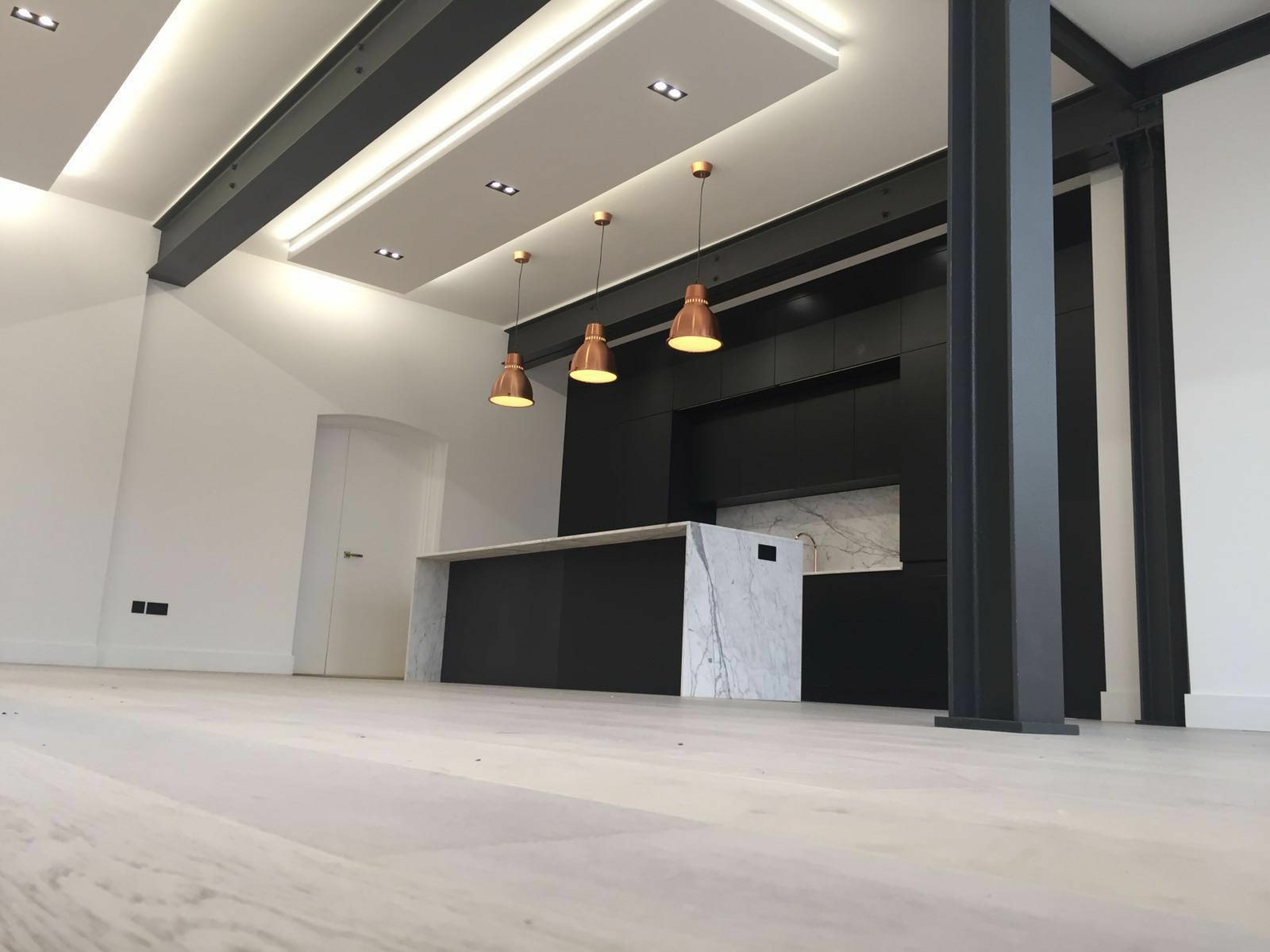 Contemporary Renova kitchen refurbishment with marble island, dark cabinetry and architectural lighting