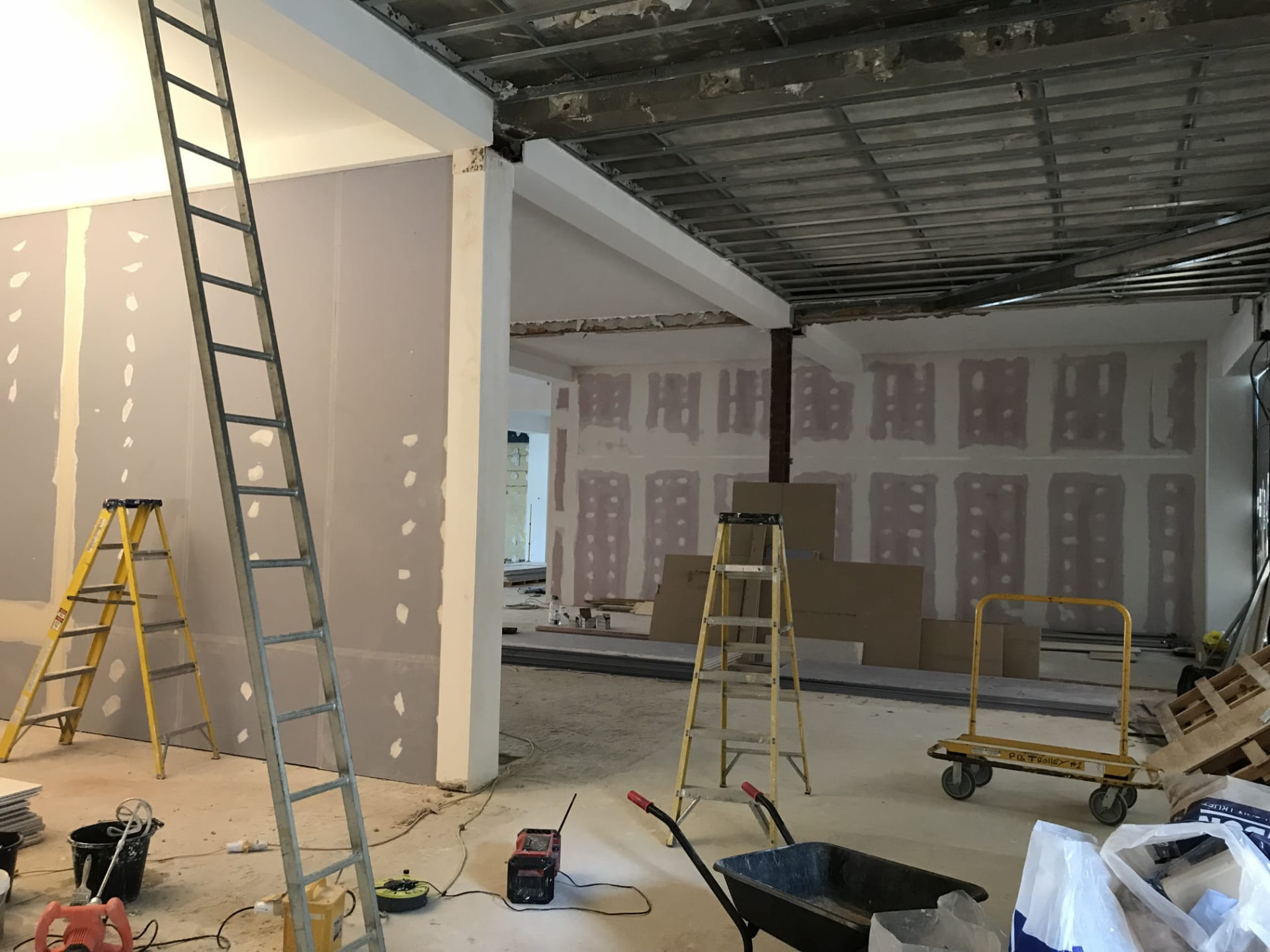 Interior mid-works with newly boarded and jointed plasterboard walls, ladders and site equipment