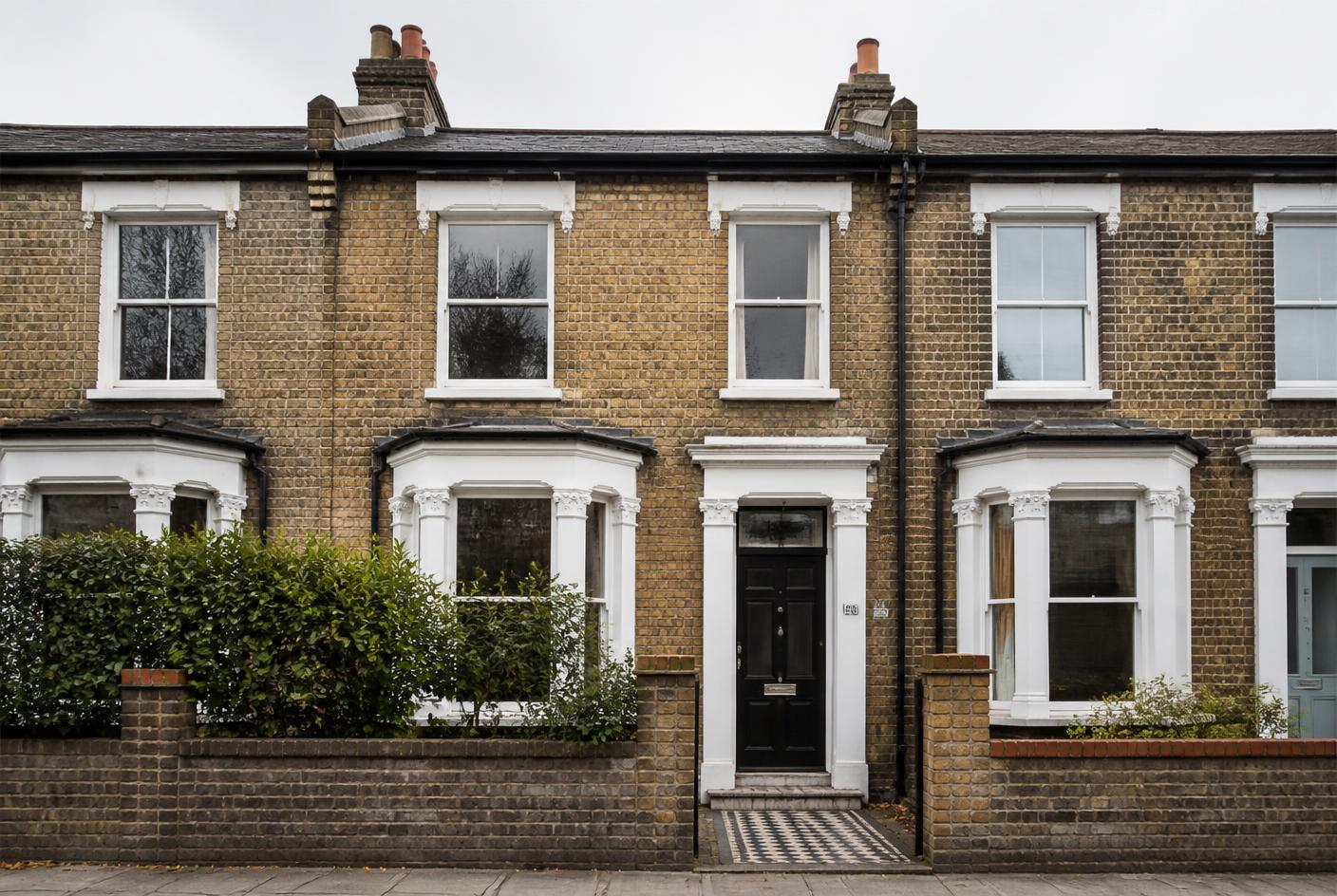 Victorian terraced house facade in London with black front door