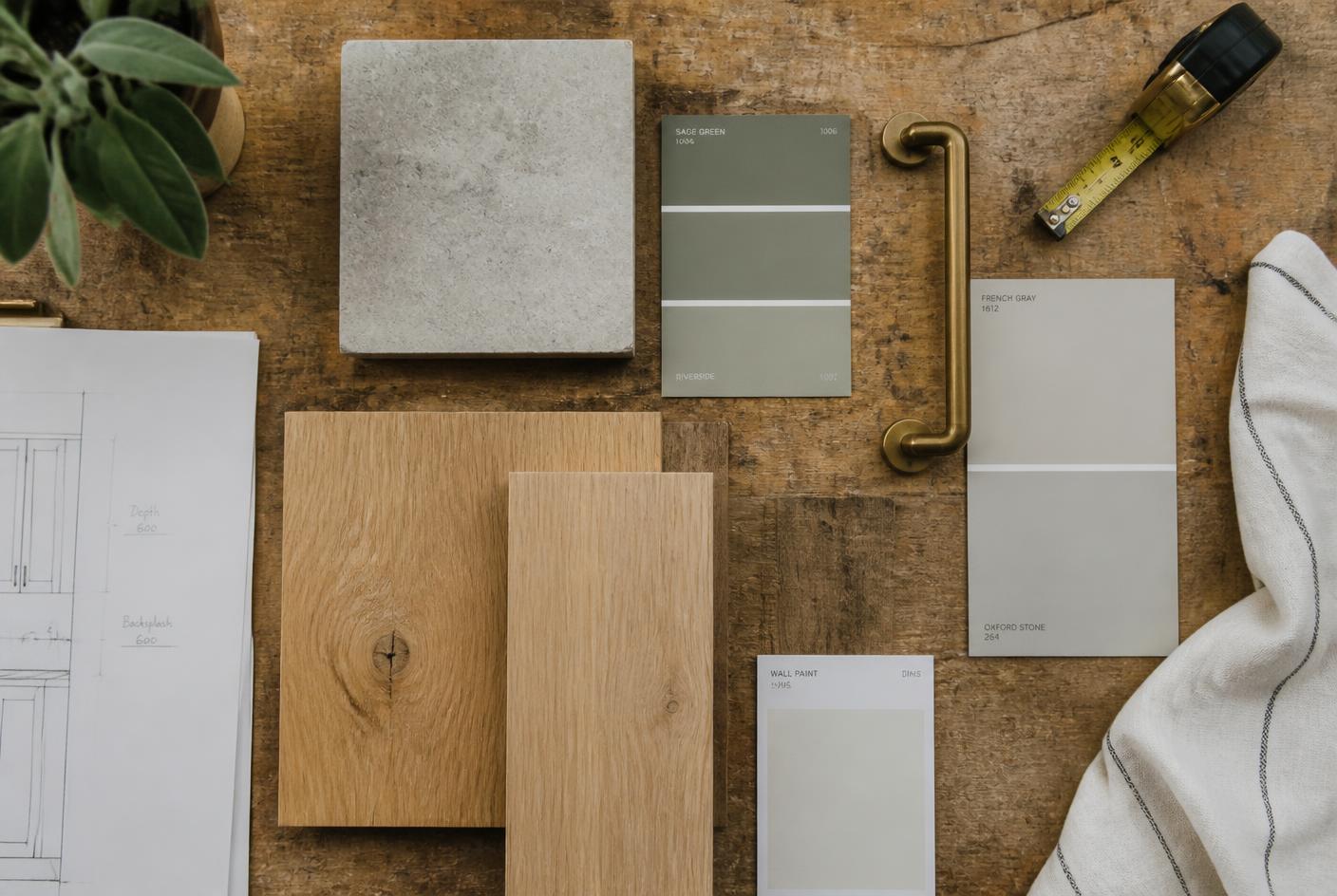Flat lay of oak samples, stone tile and paint swatches on a workbench